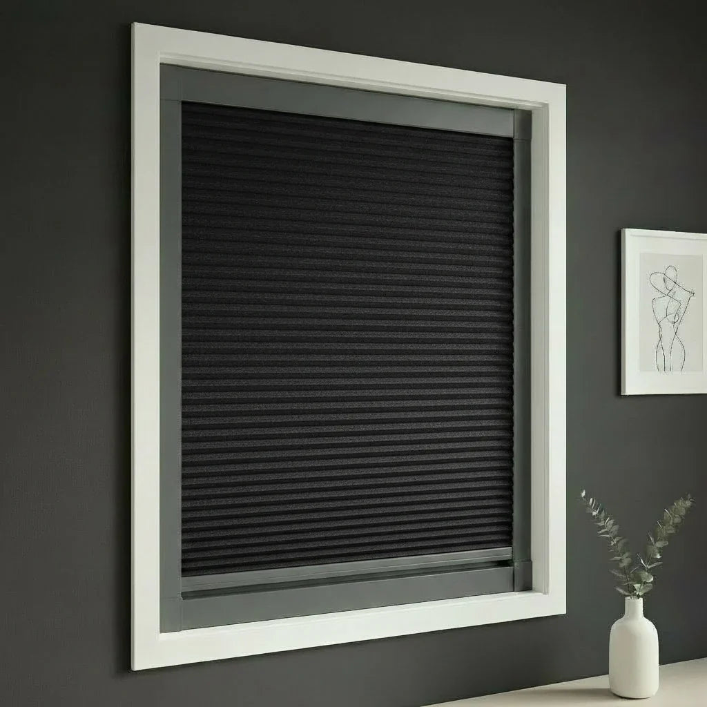 FAIZ blackout cellular blind in Black fabric with Dark Grey rail, shown for an insulated blackout home environment.