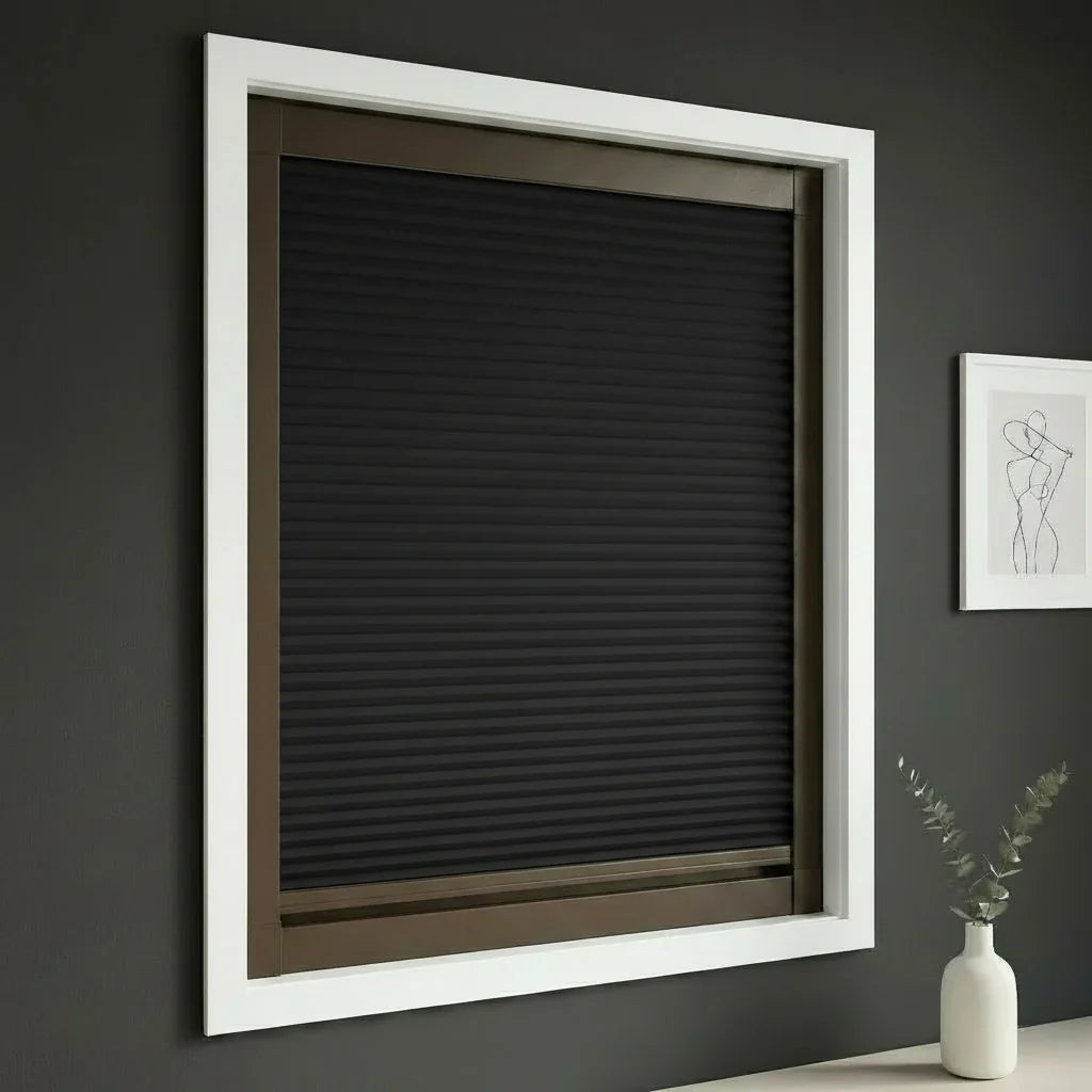 FAIZ blackout cellular blind in Black fabric with Coffee Brown rail, shown for relaxing nighttime rest with full light blocking.