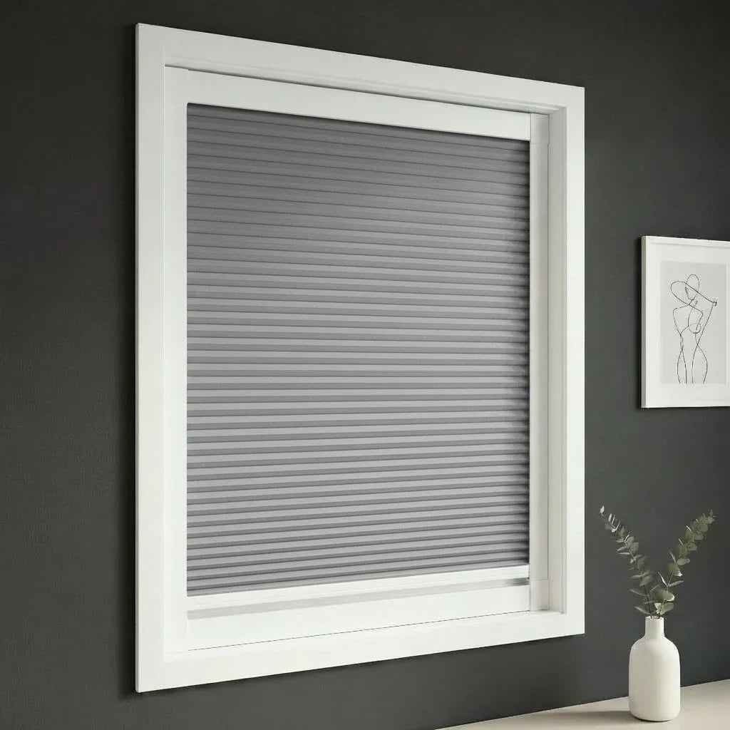 FAIZ blackout cellular blind in Dark Grey fabric with White rail, shown for total blackout at the window.