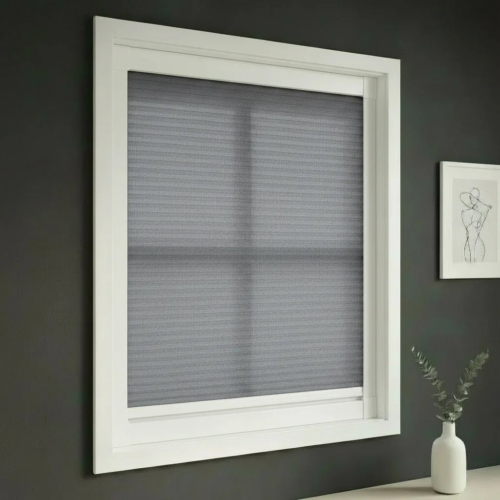 FAIZ light filtering cellular blind in Grey fabric with White rail, shown for calm bedroom light control.
