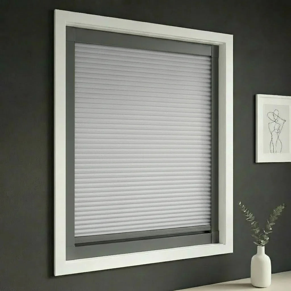 FAIZ blackout cellular blind in Light Grey fabric with Dark Grey rail, shown to support sleep with dependable light blocking.