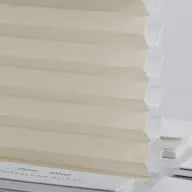 Light khaki cellular fabric filtering glare in a calm room