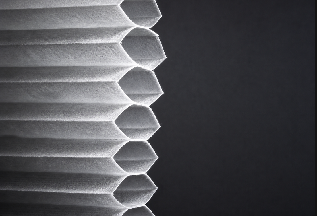 Silver-white cellular shade fabric showing complete honeycomb air pockets for thermal insulation