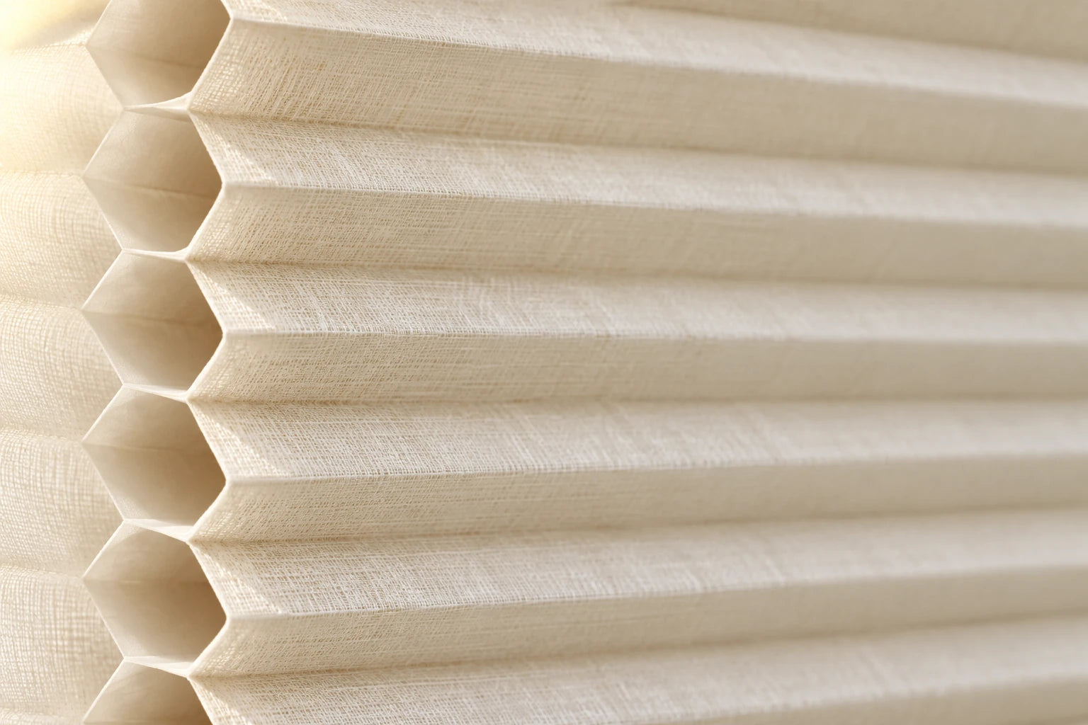 Illustrative ivory cellular fabric surface and open honeycomb edge